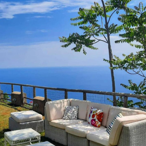 Salon extérieur de l’Agriturismo Sant’Alfonso à Furore avec canapé et vue sur la mer.
