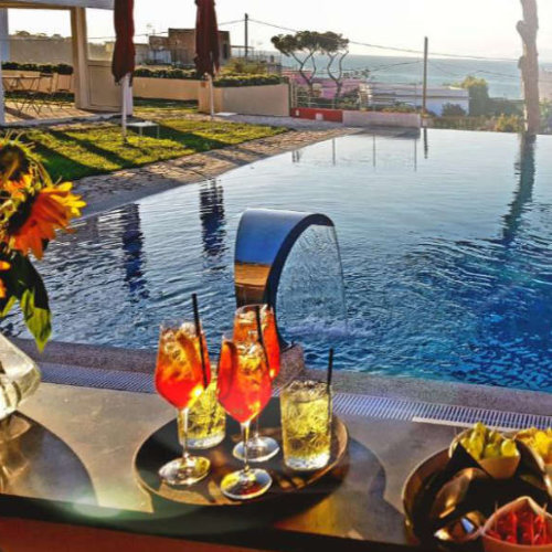 Cocktails au bord d'une piscine à débordement face à la mer.