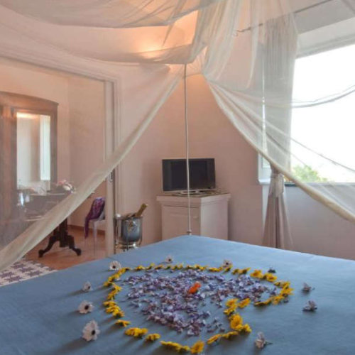 Chambre romantique avec un cœur en pétales de fleurs sur le lit.