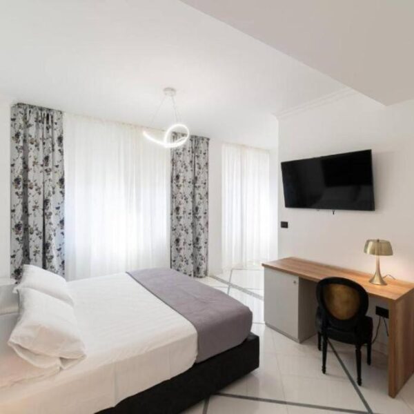 Chambre lumineuse avec coin bureau chez Suite Italy dans le quartier Chiaia à Naples.