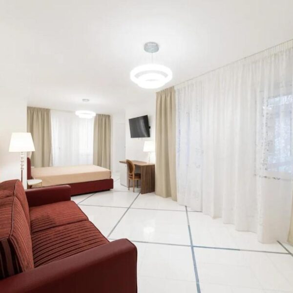 Suite avec canapé rouge et décoration moderne entre Chiaia et Mergellina à Naples.