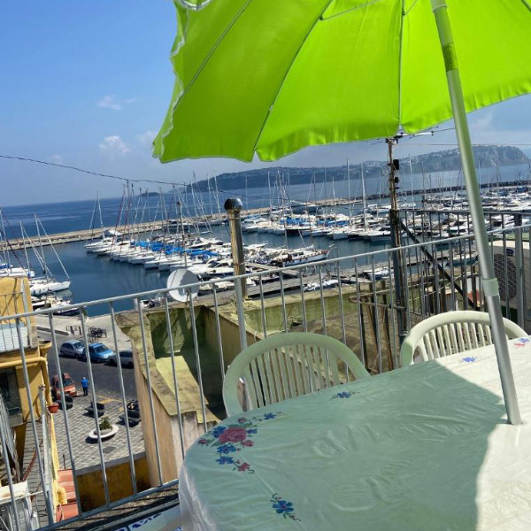 Terrasse aménagée avec parasol offrant une vue panoramique sur le port de Marina Grande.