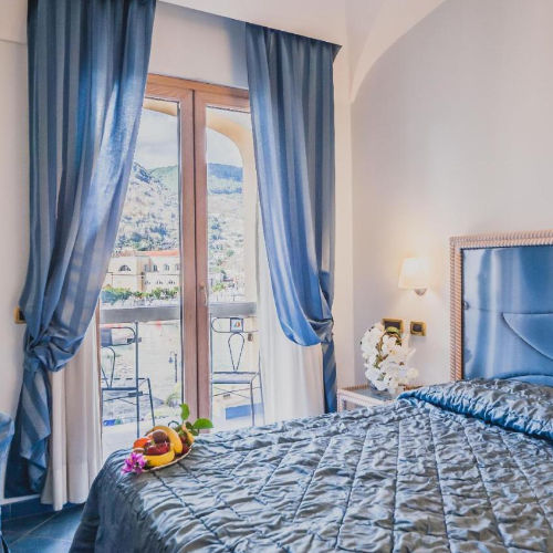 Chambre raffinée avec balcon offrant une vue sur les paysages d'Ischia.