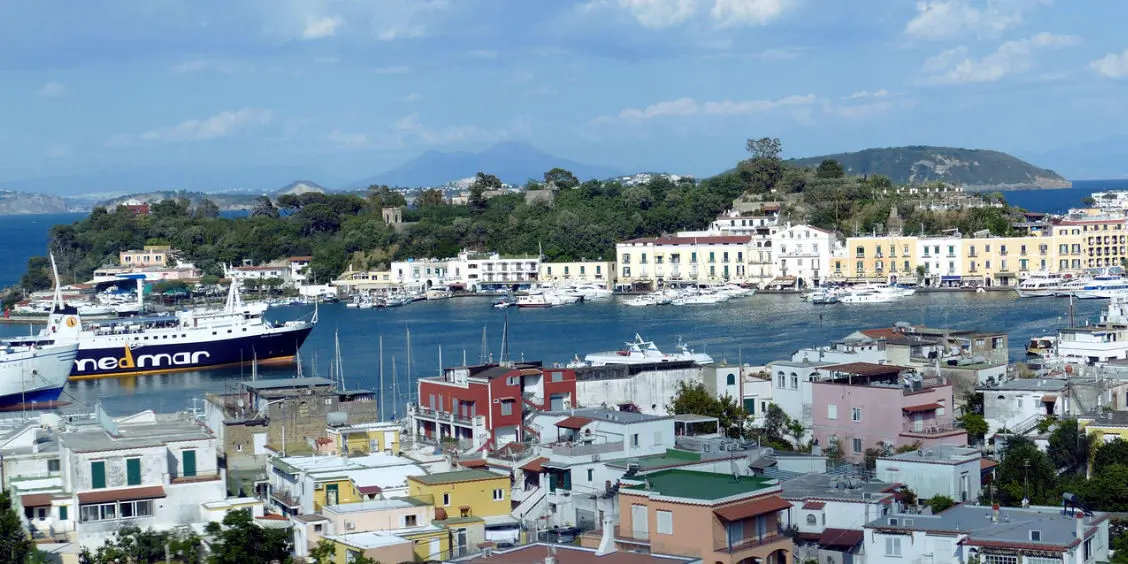 Vue panoramique sur le port d'Ischia Porto avec un ferry Medmar à l'approche.