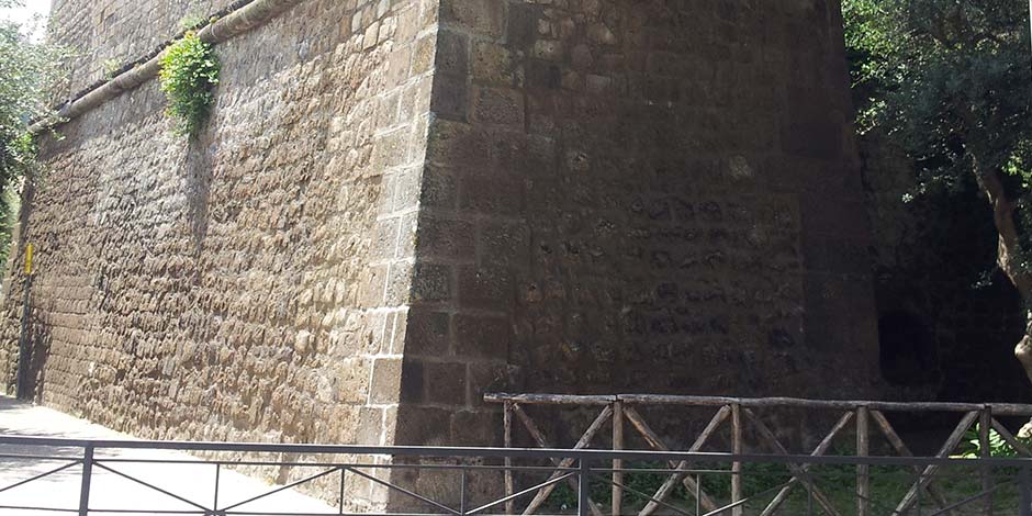 Bastion de Parsano à Sorrente avec murs défensifs en pierre et rambarde en bois.