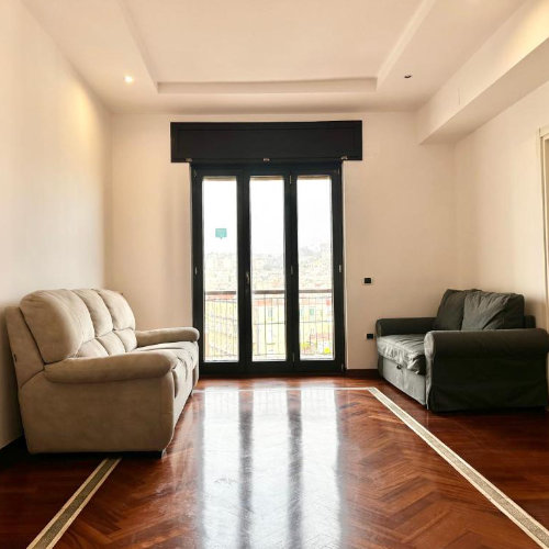 Salon d’un appartement à Naples avec canapé et balcon donnant sur la ville.