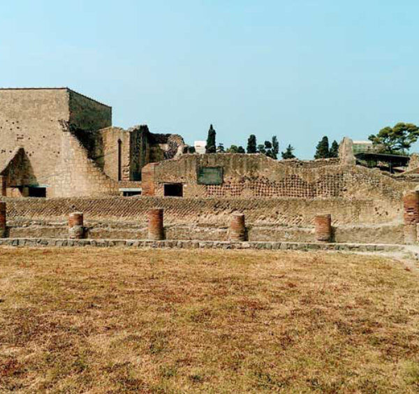 Ruines d’Herculanum avec vestiges antiques, murs en pierre et colonnes basses.