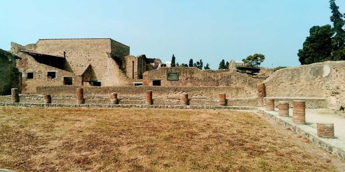 Ruines d’Herculanum avec vestiges antiques, murs en pierre et colonnes basses.