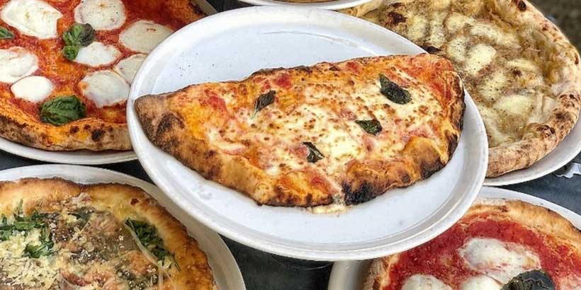 Pizzas napolitaines variées avec mozzarella, tomate et basilic, dont une calzone, spécialités typiques de Naples.