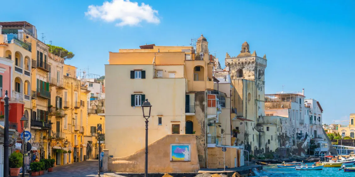 Rue pittoresque d'Ischia Ponte avec ses bâtiments colorés et vue sur la mer.