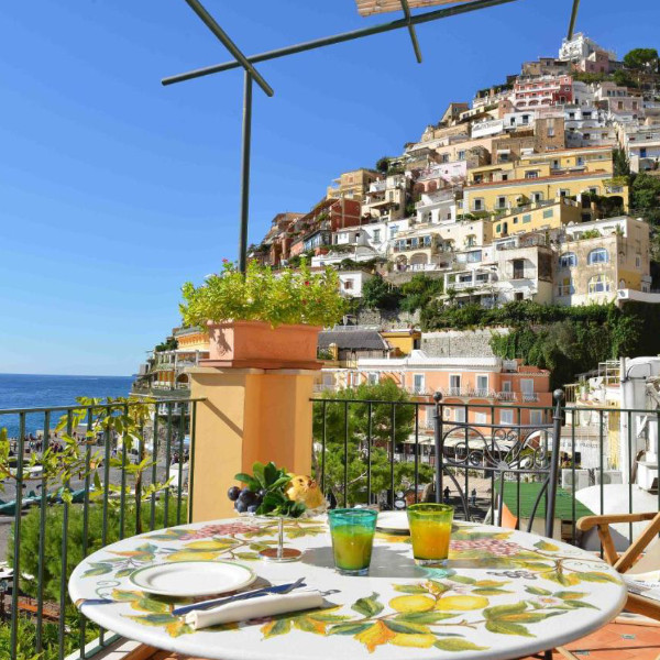 Terrasse du Buca di Bacco à Positano avec table décorée et vue sur le village.