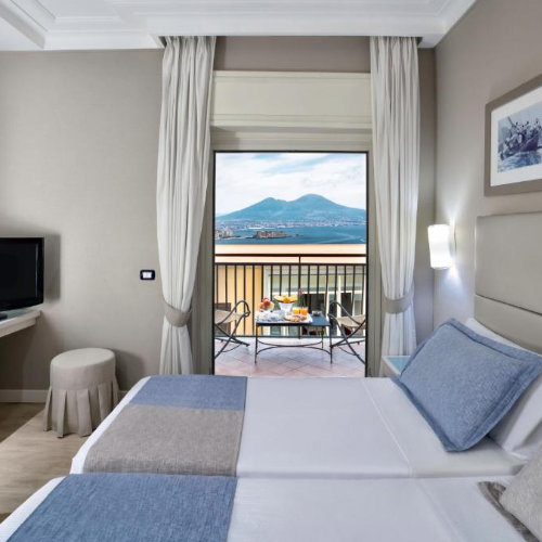 Chambre élégante avec balcon privé donnant sur le Vésuve et la baie de Naples.
