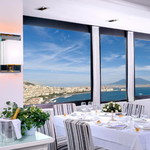 Restaurant panoramique de l'Hôtel Paradiso avec vue sur la mer et le paysage urbain napolitain.