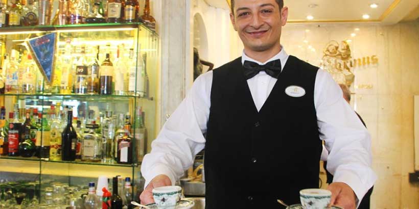 Serveur du café Gambrinus à Naples servant deux expressos, dans un établissement historique emblématique de la ville.