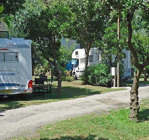 Camping-cars stationnés à l'ombre des arbres dans un camping à Pompéi.