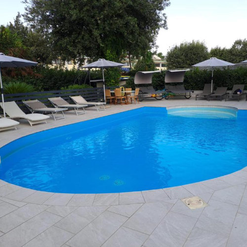 Piscine extérieure du Capodichino International Hotel à Naples avec transats et espace détente.