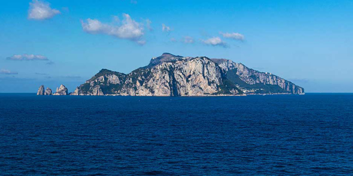 Vue panoramique de la silhouette rocheuse de l'île de Capri émergeant des eaux bleues de la Méditerranée.