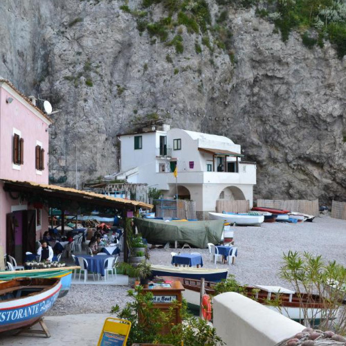 Maisons de pêcheurs et restaurant sur la plage de Conca dei Marini au pied de la falaise.