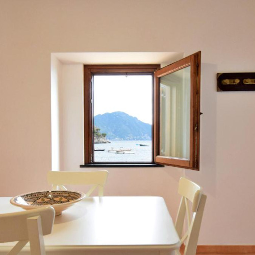Fenêtre ouverte sur la mer depuis la salle à manger lumineuse de la Casa della Marina.