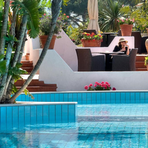 Piscine extérieure azur et terrasse fleurie à l'Hôtel Casa di Meglio.