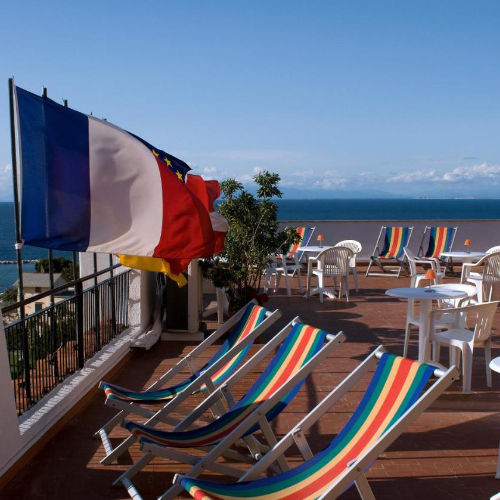 Terrasse panoramique avec chaises longues rayées et vue sur l'horizon à l'Hôtel Casa di Meglio.