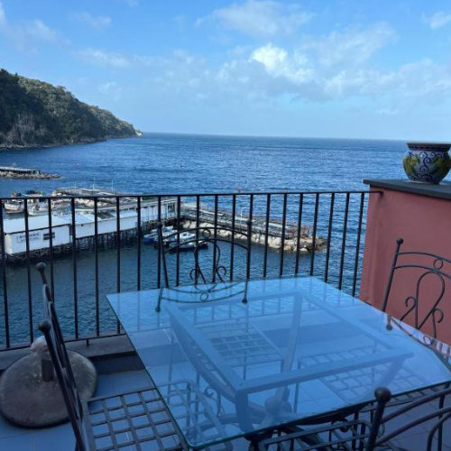 Terrasse avec table en verre à Sorrente, balcon sur la mer et vue sur le port.