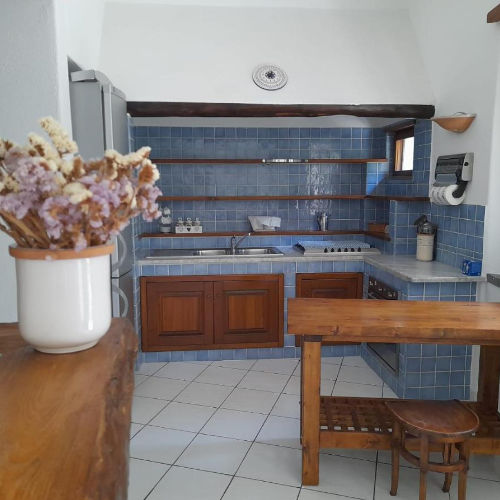 Cuisine rustique de la Casa Mandarino avec carrelage bleu et mobilier en bois.