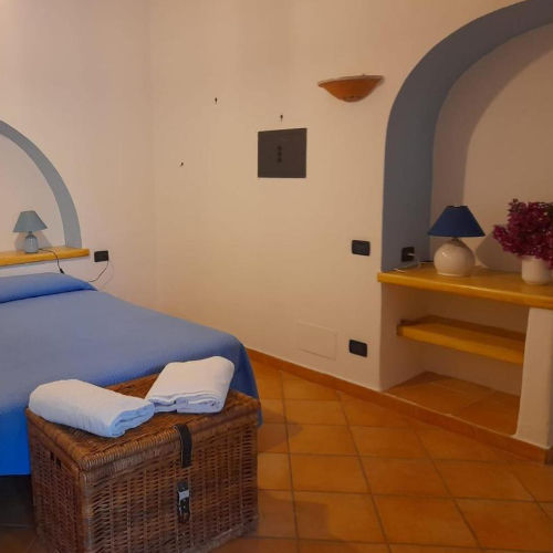 Chambre à coucher de la Casa Mandarino décorée de bleu avec sol en terre cuite.
