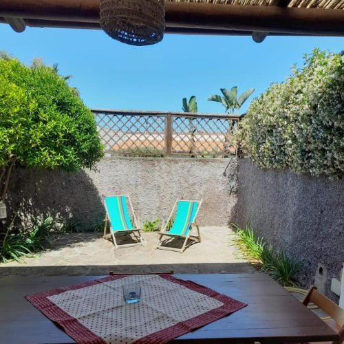 Terrasse extérieure ensoleillée de la Casa Mandarino avec chaises longues et jardin.