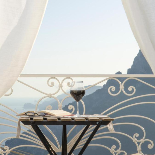Balcon de Casa Romelide à Positano avec verre de vin et vue sur la mer.
