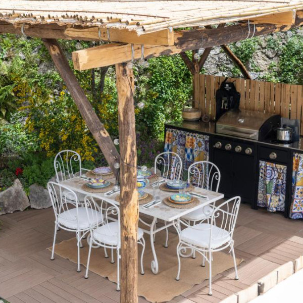 Terrasse de Casa Romelide à Positano avec table extérieure et cuisine d’été.