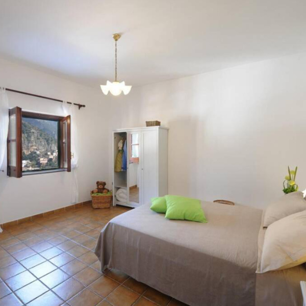 Chambre de Casa Siria à Positano avec fenêtre donnant sur les montagnes.
