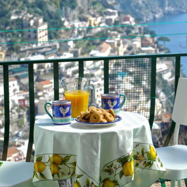 Petit-déjeuner sur le balcon de Casa Siria à Positano avec vue panoramique sur la mer.