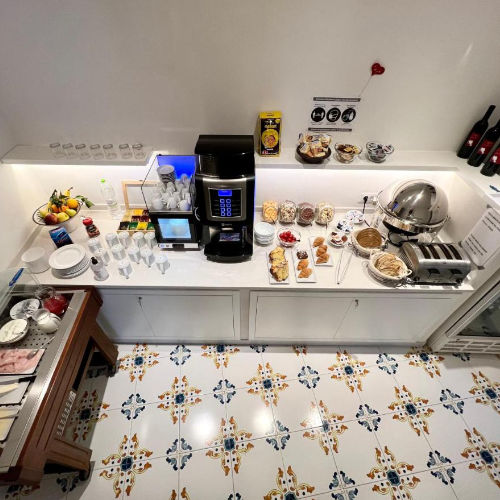 Buffet du petit-déjeuner varié sur un sol en faïence aux motifs méditerranéens.