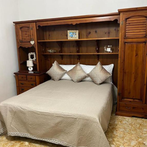 Chambre avec lit double et grand meuble pont en bois massif.