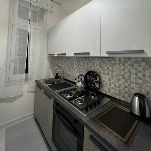 Petite cuisine moderne avec meubles gris et blancs.