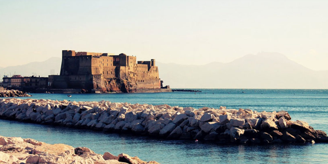 Castel dell’Ovo à Naples sur la mer, avec digue rocheuse et vue sur le golfe.