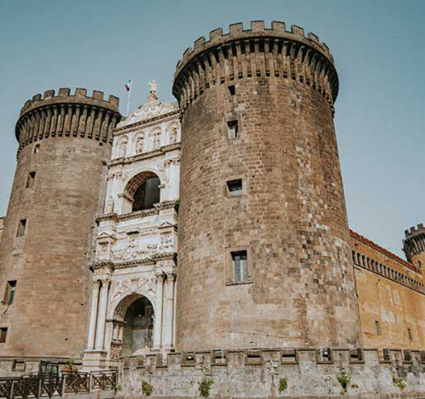 Castel Nuovo (Maschio Angioino) à Naples avec tours médiévales et arc de triomphe en façade.