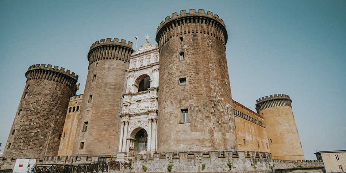 Castel Nuovo (Maschio Angioino) à Naples avec tours médiévales et arc de triomphe en façade.