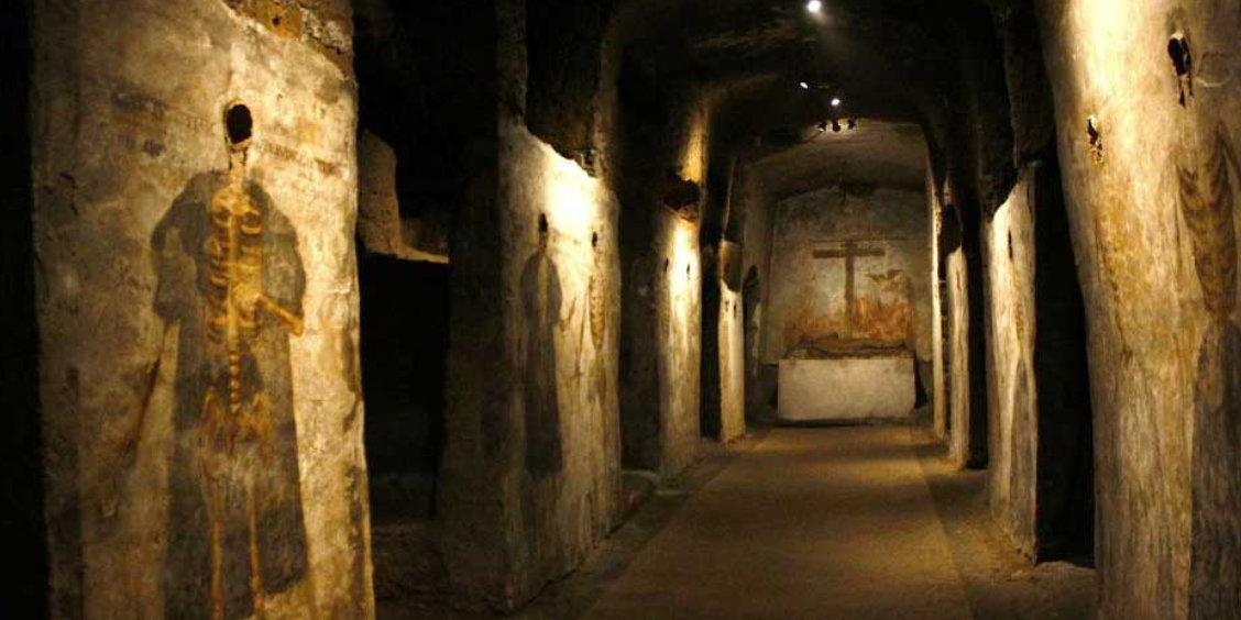 Catacombes de San Gaudioso à Naples avec fresques, couloir souterrain et art funéraire ancien.