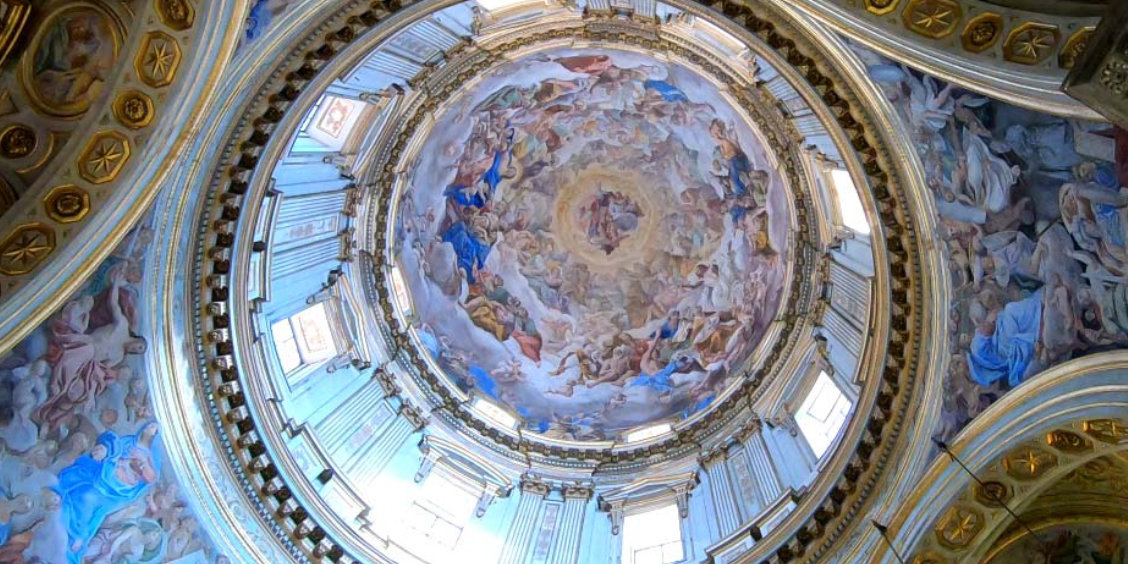 Coupole richement décorée de fresques à l’intérieur d’une cathédrale à Naples, avec scènes religieuses et ornements baroques.
