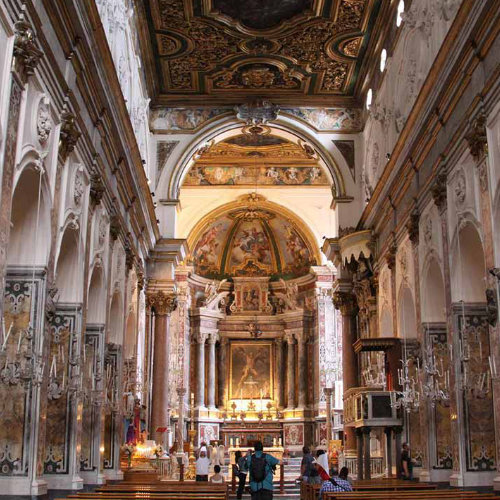 Intérieur de la cathédrale de Sant’Andrea à Amalfi avec nef, autel et plafond décoré.