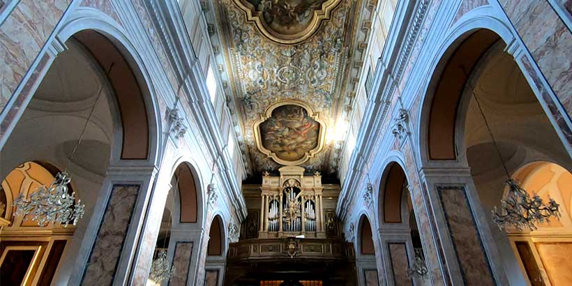Intérieur de la cathédrale de Sorrente avec arches, orgue et plafond décoré.