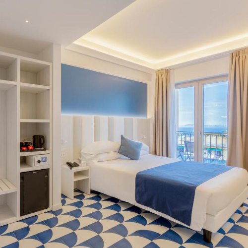 Chambre du Central Wellness à Sorrente avec balcon et décoration bleue.