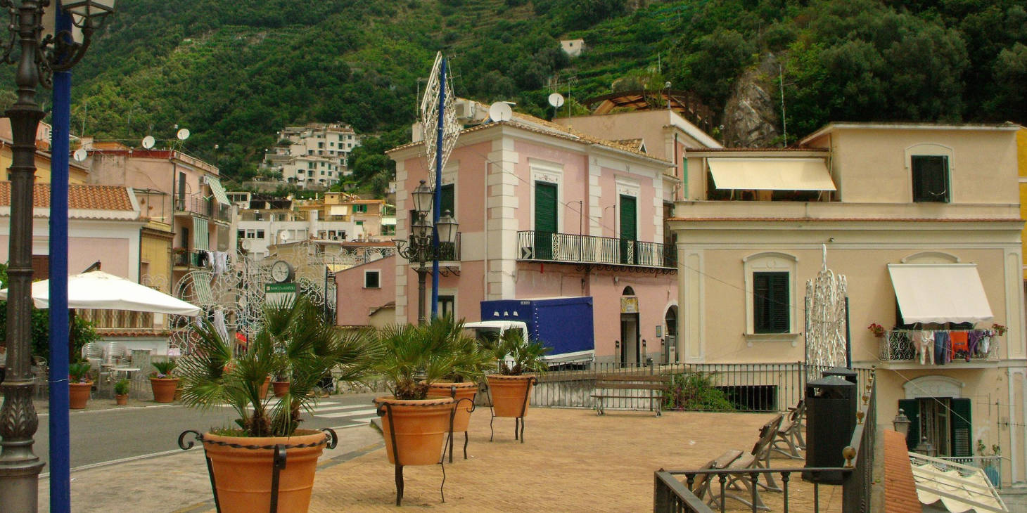 Vue du centre historique de Cetara avec ses maisons roses et ses plantes en terrasse.