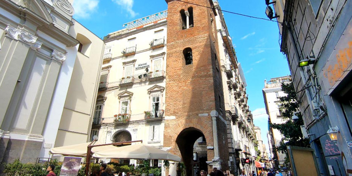 Ruelle animée et architecture ancienne au cœur du centre historique de Naples.