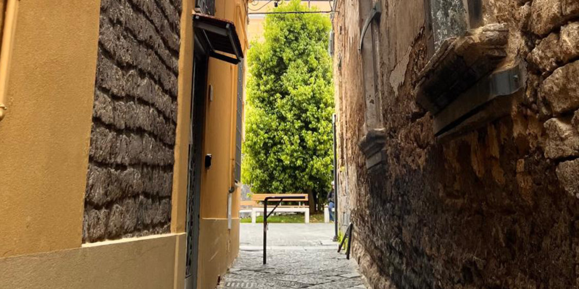Ruelle du centre historique de Sant’Agnello, avec murs en pierre, passage étroit et jardin méditerranéen.