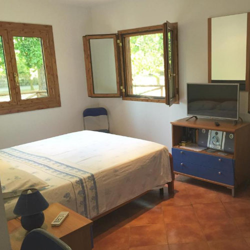 Chambre simple d’une maison à Sorrente avec fenêtres en bois, lit double et télévision.