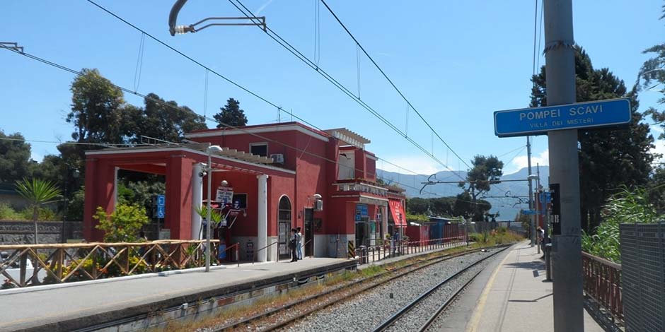 Quai de la gare Pompei Scavi - Villa dei Misteri avec son bâtiment rouge et son panneau bleu caractéristique.