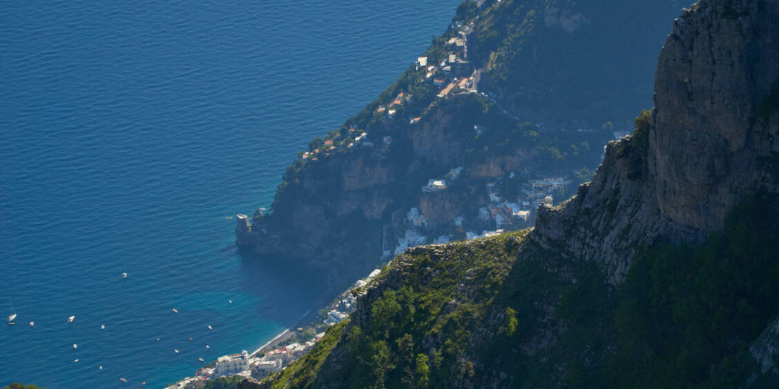 Vue sur la Côte Amalfitaine depuis les hauteurs avec falaises escarpées, villages et mer Méditerranée.
